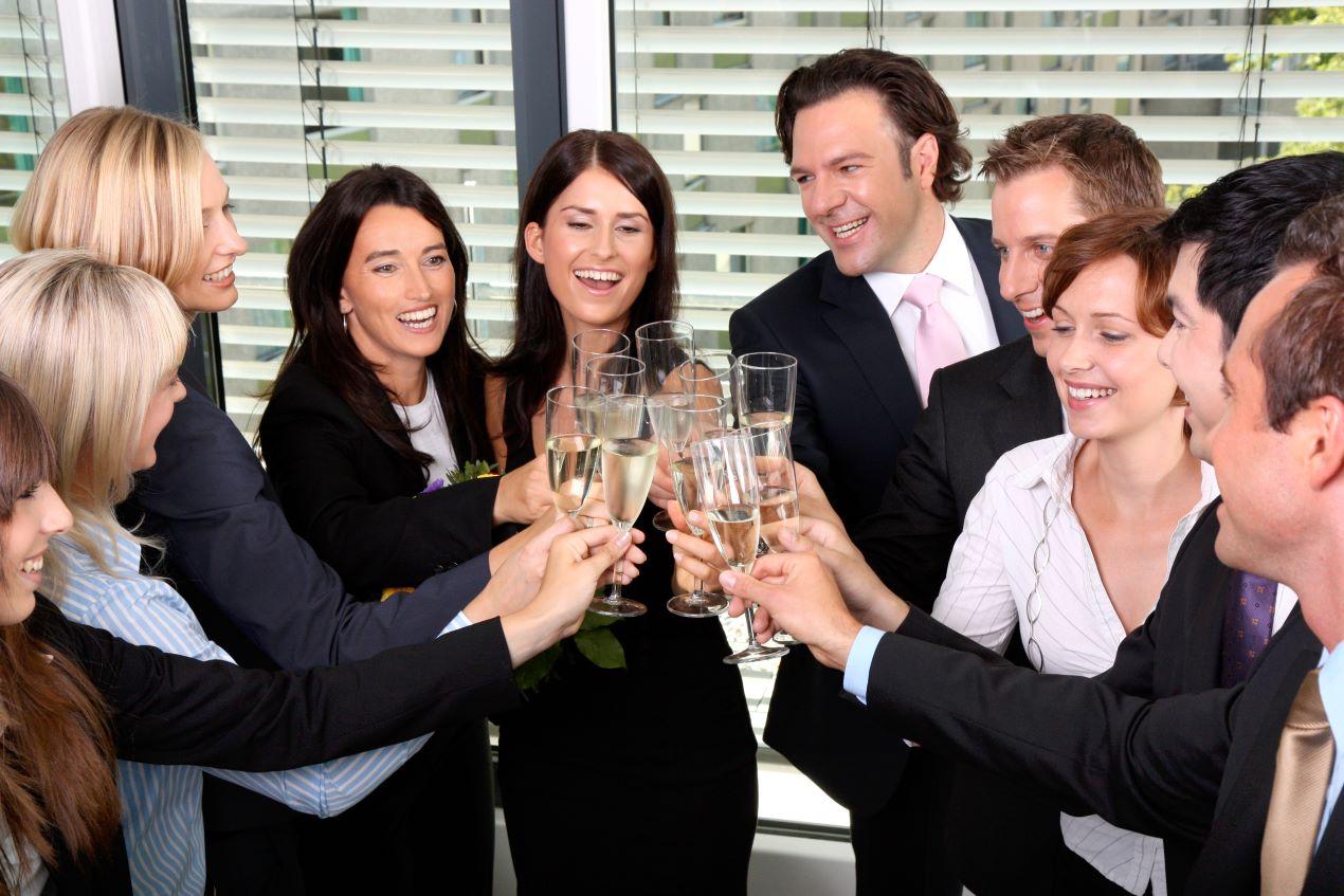 Ein Team stößt bei einer Firmenfeier mit Sekt an – ein Zauberer kann das Event mit magischer Unterhaltung bereichern.