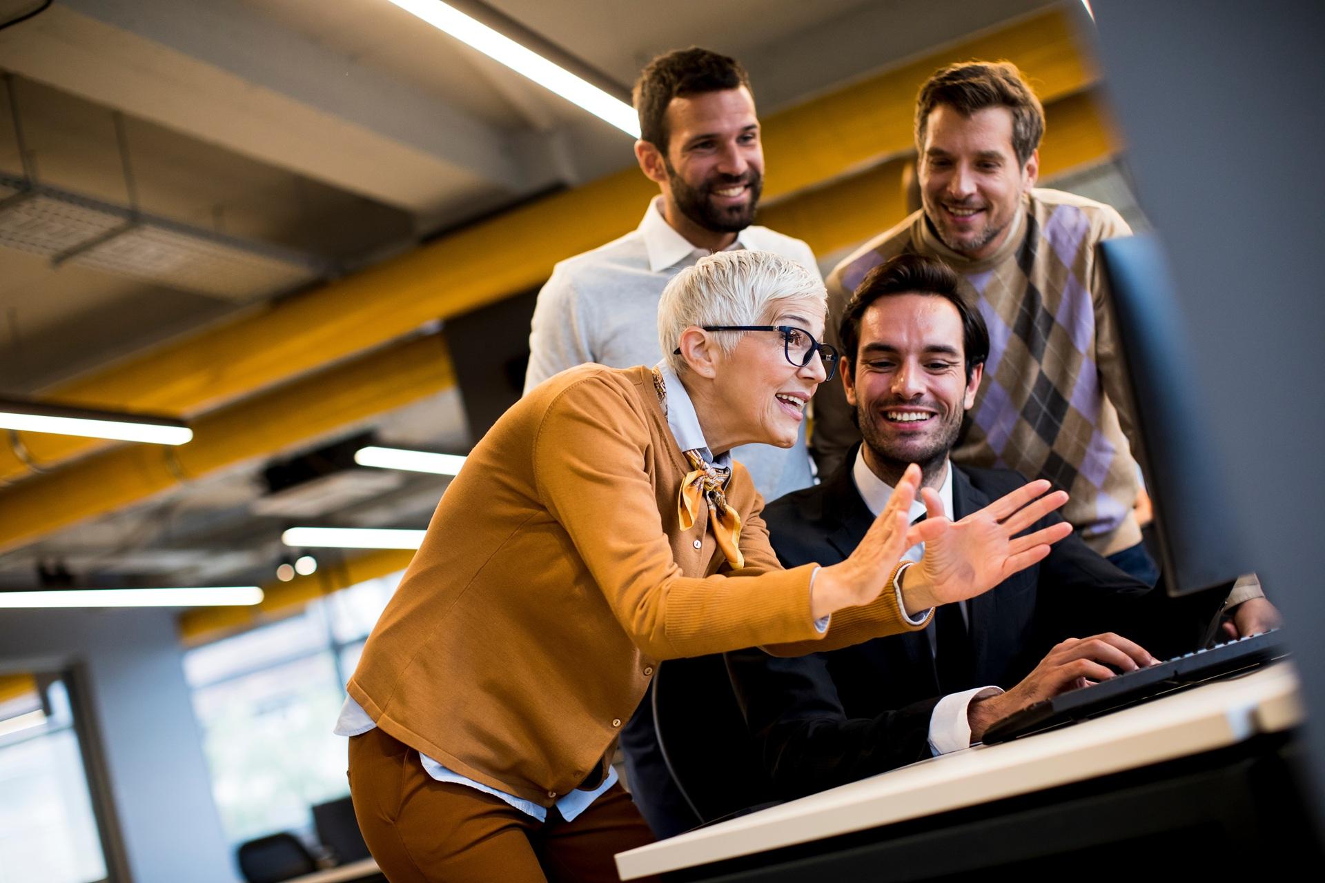 Motiviertes Team arbeitet gemeinsam am Schreibtisch | Lohnabrechnung Outsourcing