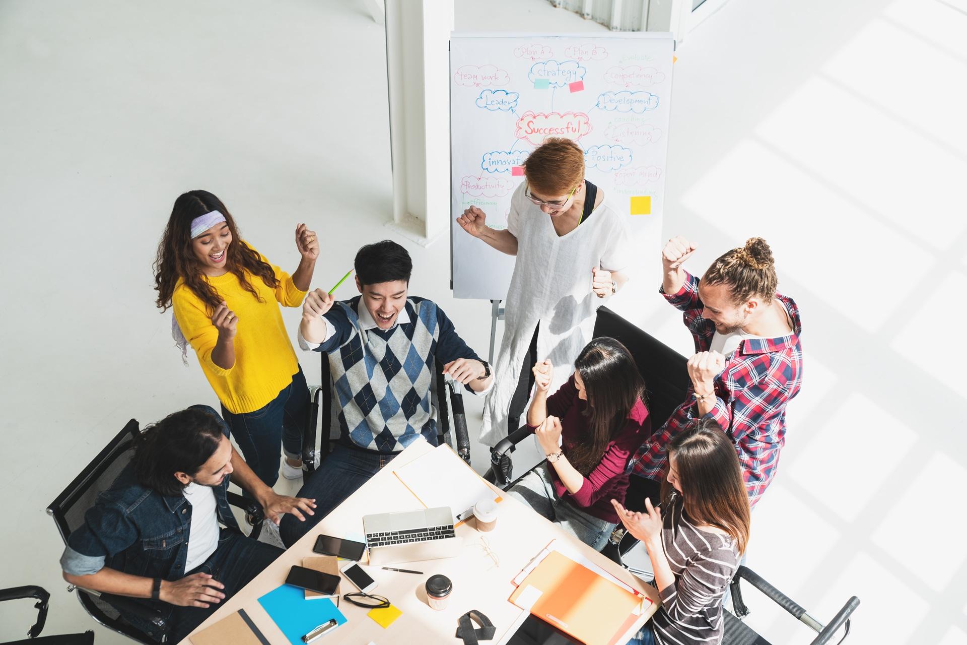 Zufriedenes Team posiert gemeinsam und zeigt Zusammenhalt | Lohnabrechnung Outsourcing